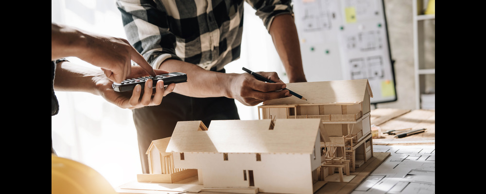 Two Black men work on construction plans