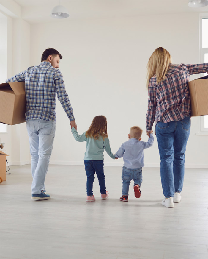 family holding hands while moving into their new home